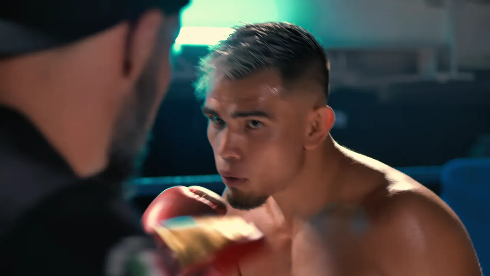 A boxer training on pads in the ring