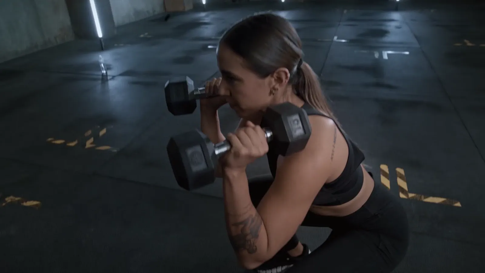 A woman pressing dumbbells overhead
