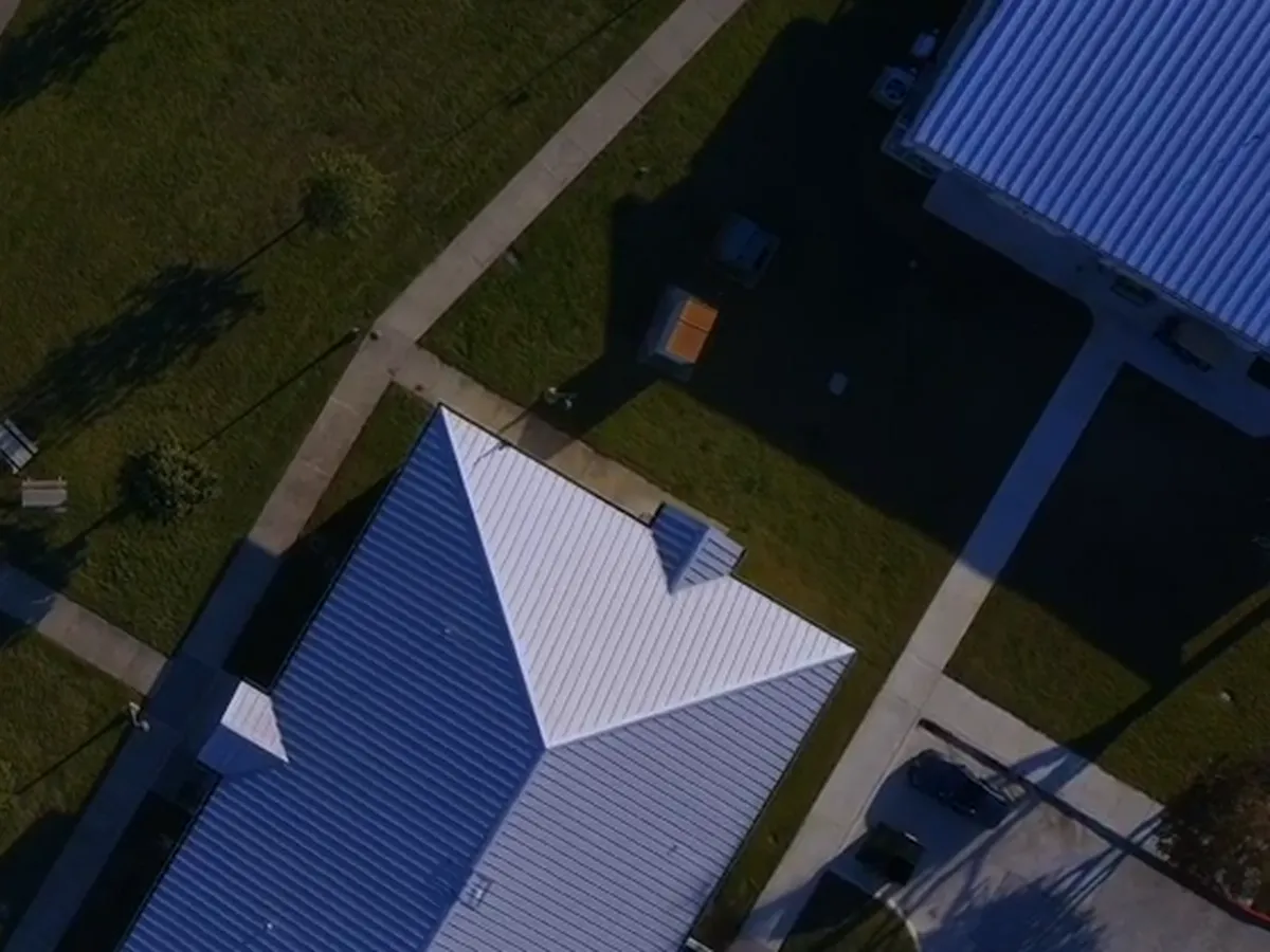 Close aerial view of one hipped metal roof
